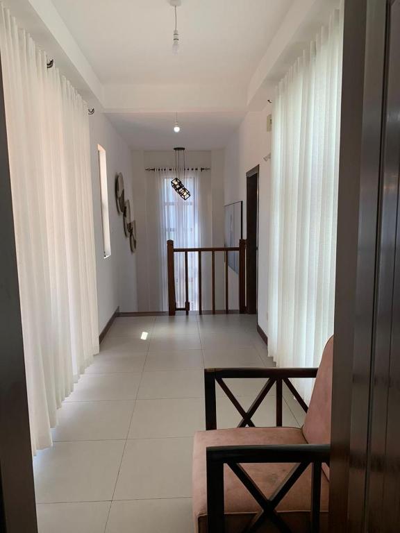 een woonkamer met witte gordijnen en een bank bij Luxurious Beachfront Villa with Private Pool - Sultan Palace in Kilifi