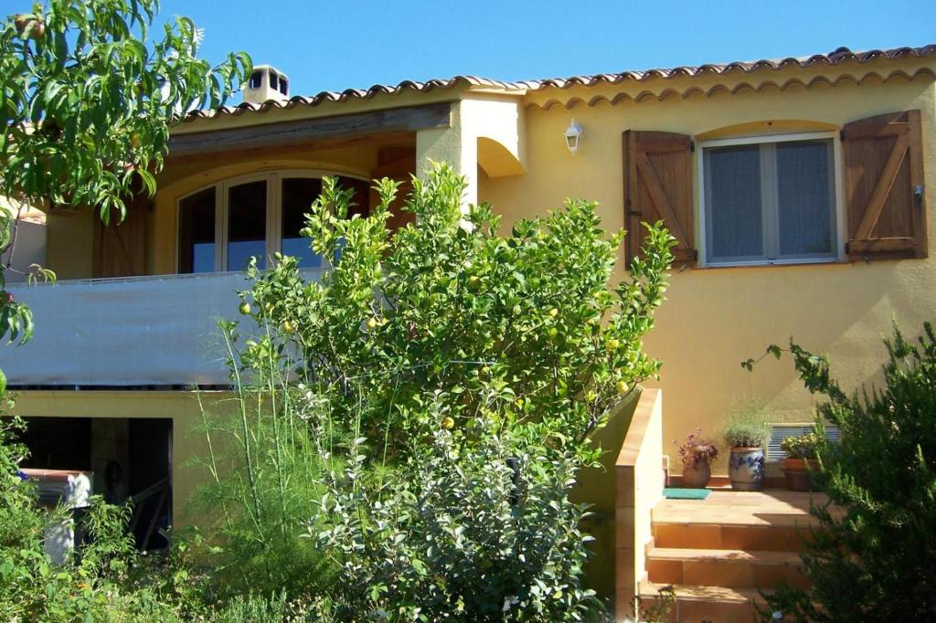 une maison jaune avec un arbre devant elle dans l'établissement Le gite les amandiers, à Laouque