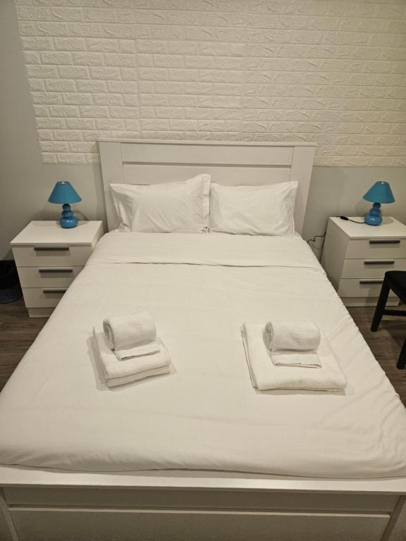 un letto bianco con due asciugamani sopra di BeU Guesthouse a Ponta Delgada