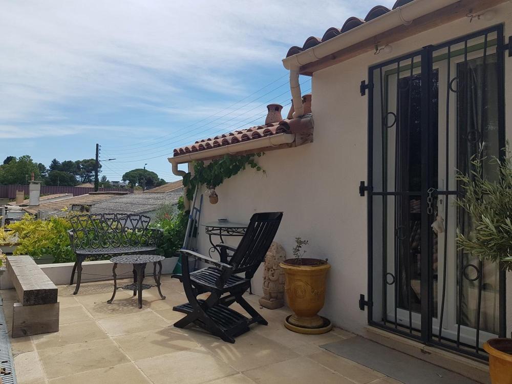 un patio avec deux chaises et une table sur un balcon dans l'établissement appartement sur les toits, à Montpellier