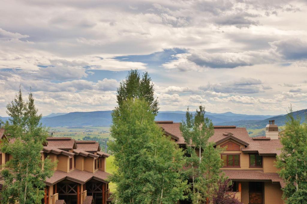 a view of a building with trees and mountains in the background at Pool, Hot Tub, Sauna, Amazing Ski Area Views, Partially Covered Patio in Steamboat Springs