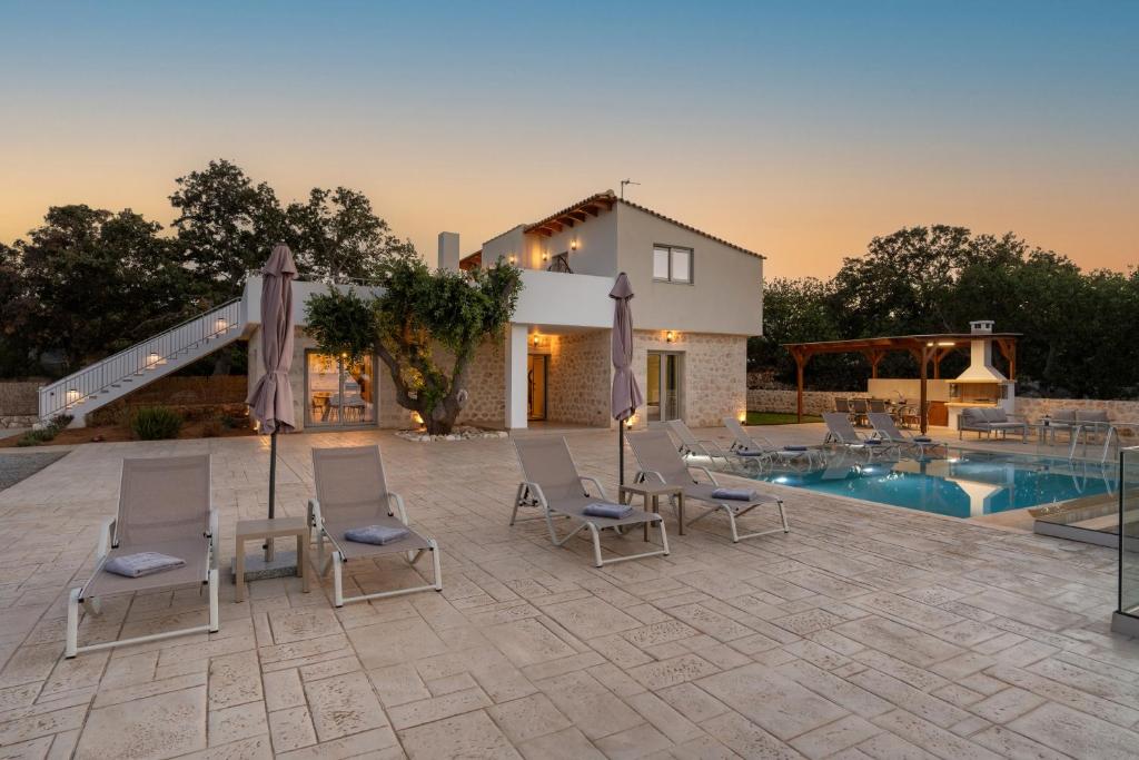 een groep stoelen naast een zwembad bij Miroy Sea View Villa in Atsipopoulo