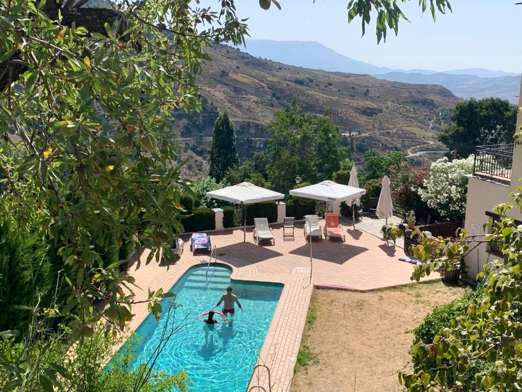 a swimming pool with a person in the water at Apartamento en Bérchules in Bérchules