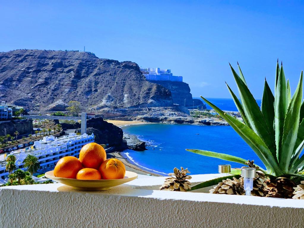 a bowl of oranges on a ledge with a view of the ocean at Top Flor Ocean View in Playa del Cura