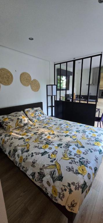 a bedroom with a bed with a blanket with birds on it at Loft de jardin le 8 in Locminé