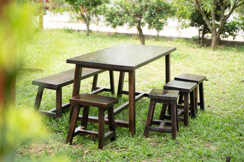 a picnic table and four stools in the grass at B&H Villa - Villa has swimming pool in Lang Co