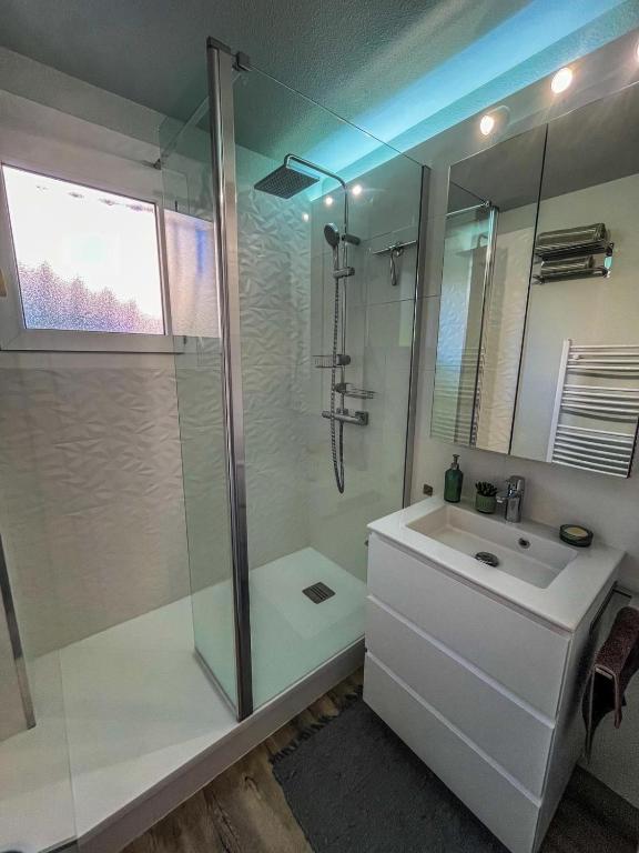 une salle de bain blanche avec une douche et un lavabo dans l'établissement Capeve, à Capbreton