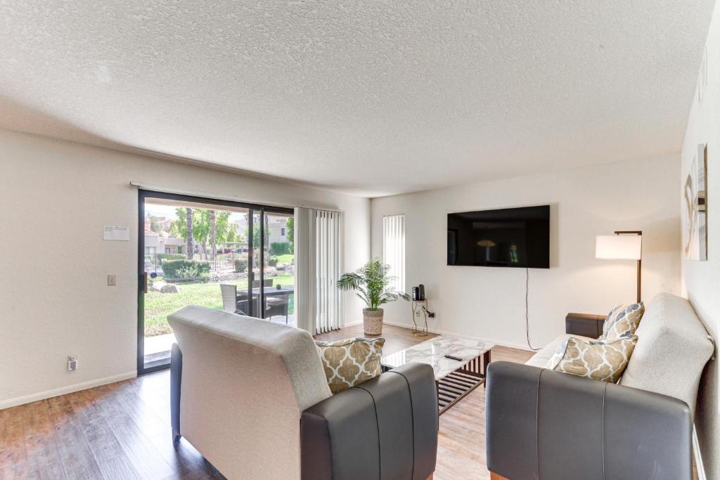 a living room with a couch and chairs and a tv at Golf, Hike and Relax Cathedral City Condo in Cathedral City
