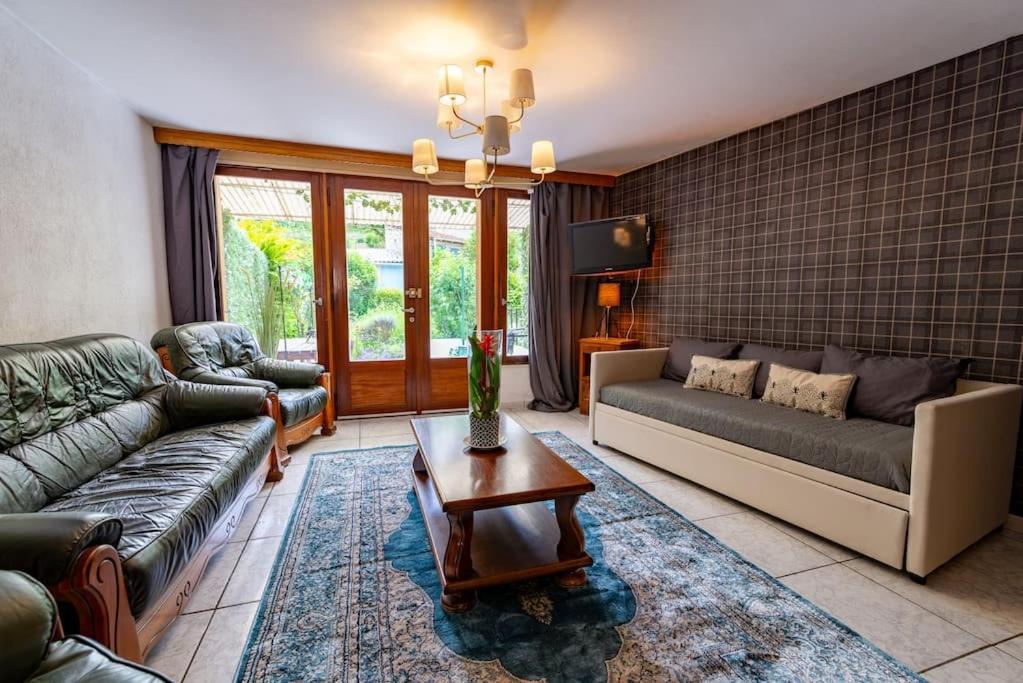 un salon avec deux canapés et une table dans l'établissement La Rosée - 2 pièces familial, jardin privatif, à Bourbonne-les-Bains