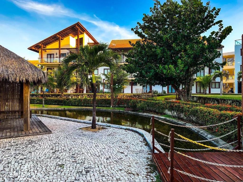 ein Resort mit einem Teich vor einem Gebäude in der Unterkunft Taiba Beach Resort - Ap 106 BL A - IMOB TEMPORADA in Taíba