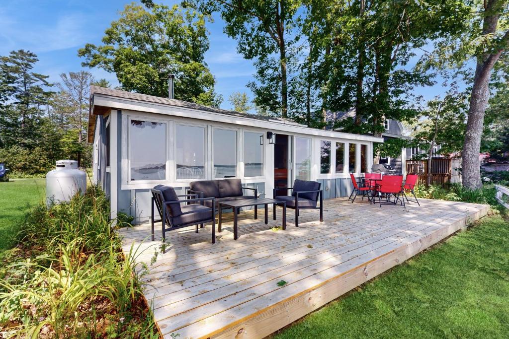 a wooden deck with chairs and a house at Sunflower Cottage in Freeport
