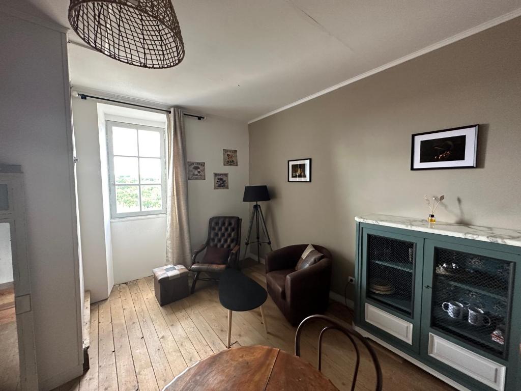 a living room with a chair and a table at Au Cœur de GENSAC, village de charme dominant la Dordogne in Gensac
