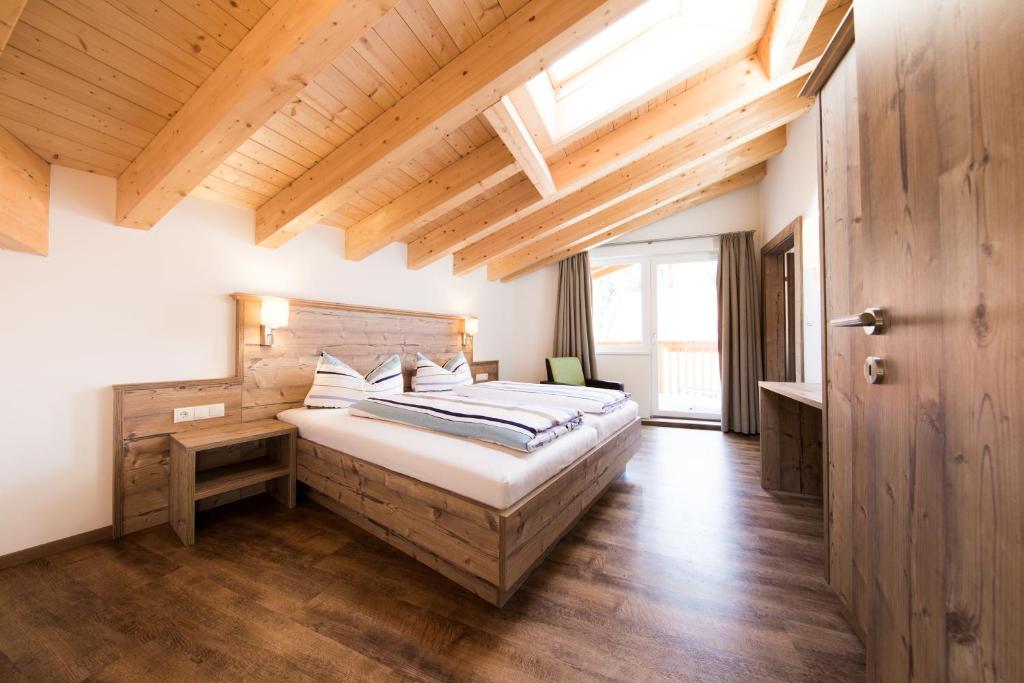 a bedroom with a large bed with a wooden ceiling at Top View - Panorama Apart Sölden in Sölden