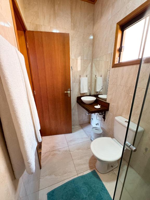 a bathroom with a toilet and a sink at Pousada Shangri-lá in Cunha