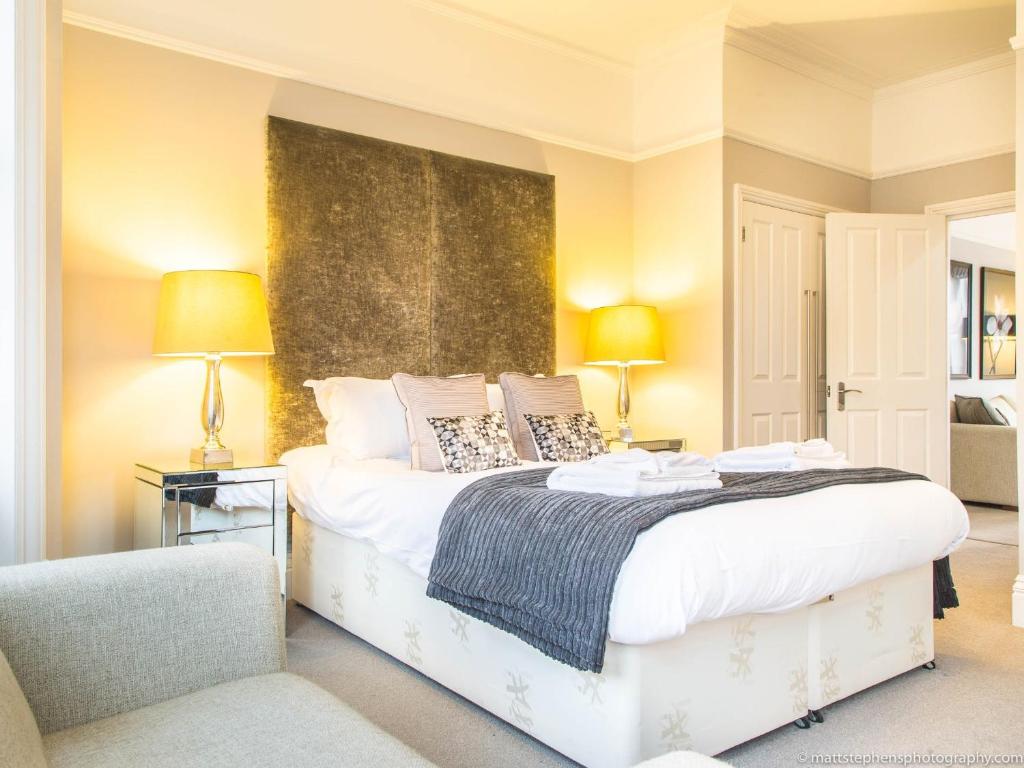 a bedroom with a large white bed with two lamps at Alum Chine Beach House in Bournemouth