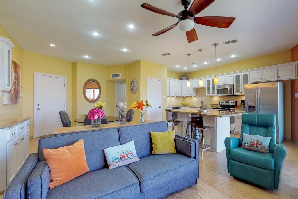 a living room with a blue couch and a kitchen at Sunchase Beachfront #210 in South Padre Island