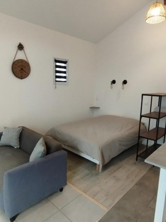 un salon avec un lit et un canapé dans l'établissement Maisonnette proche mer, à Lannion