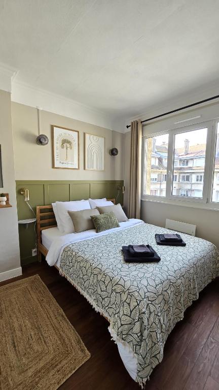 une chambre avec un grand lit avec une grande fenêtre dans l'établissement TheWatchtower plage dragon ferry à proximité, à Calais