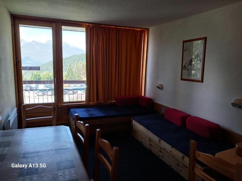 une pièce avec une table, des chaises et une fenêtre dans l'établissement Résidence Lauzieres - Studio 5 personnes skis aux pieds et proche des commerces dans le village du Charvet à Arc 1800 MAE-1901, à Arc 1800