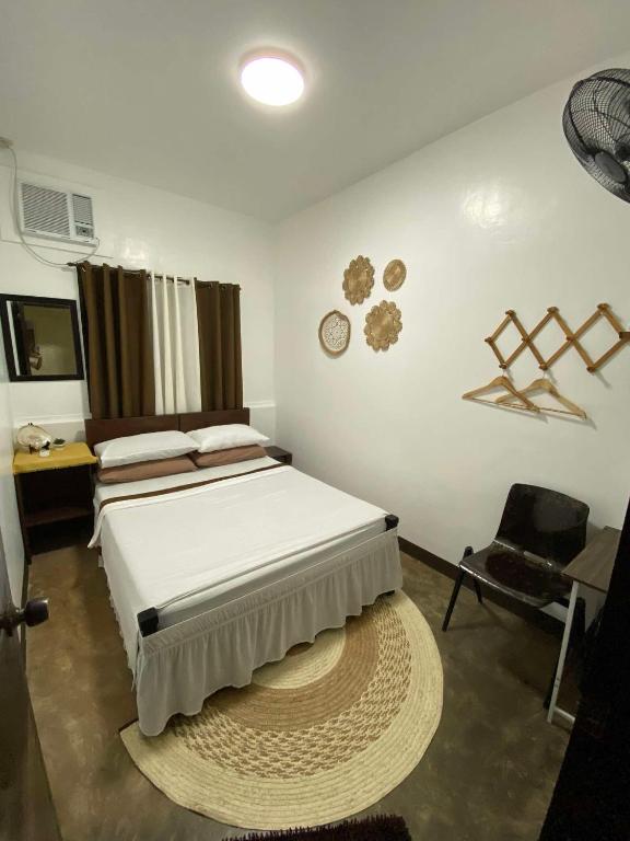 a bedroom with a large bed and a chair at Hiraya Homestay Coron in Coron