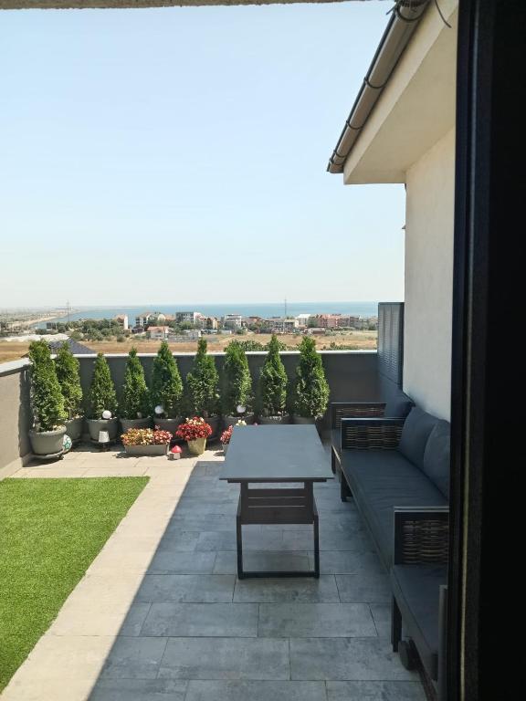 a patio with a table and a bench on a building at Perla Marii Penthouse in Eforie Nord