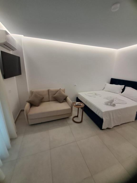 a white room with a bed and a couch at Apartments Keesi 1 in Durrës