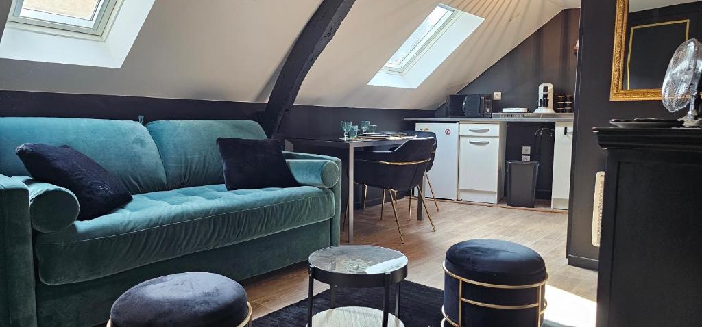 un salon avec un canapé vert et une cuisine dans l'établissement Le Paille - Studio chic cosy - HyperCentre - WIFI, au Mans