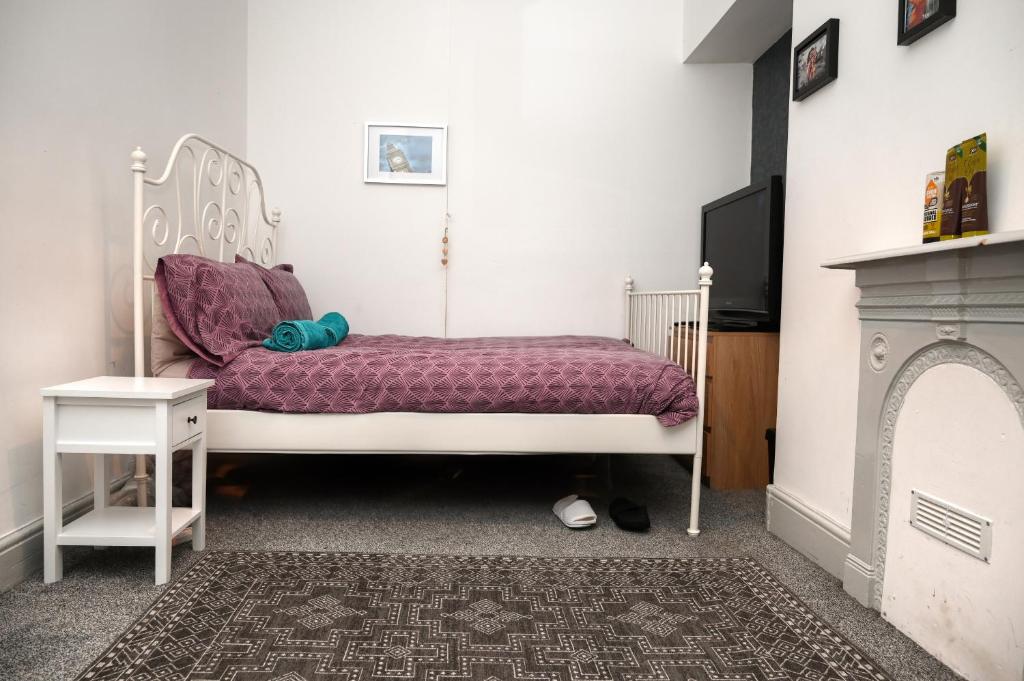 a bedroom with a white bed and a tv at Audenshaw Spacious Double Room in Manchester