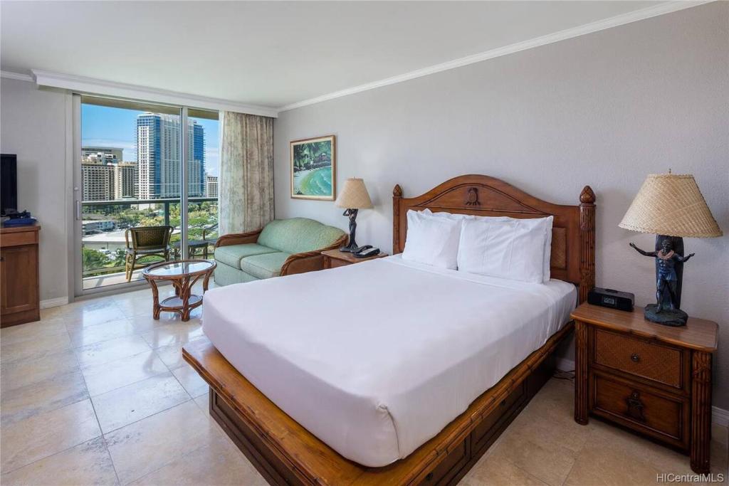 Un dormitorio con una cama grande y una sala de estar en Luana Waikiki Oceanview High Floor Condo 1210, en Honolulu