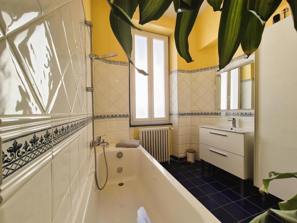a bathroom with a tub and a sink at Maison de Maître L Oustal des Halles avec salle de cinéma, billard & Jacuzzi in Castelnaudary