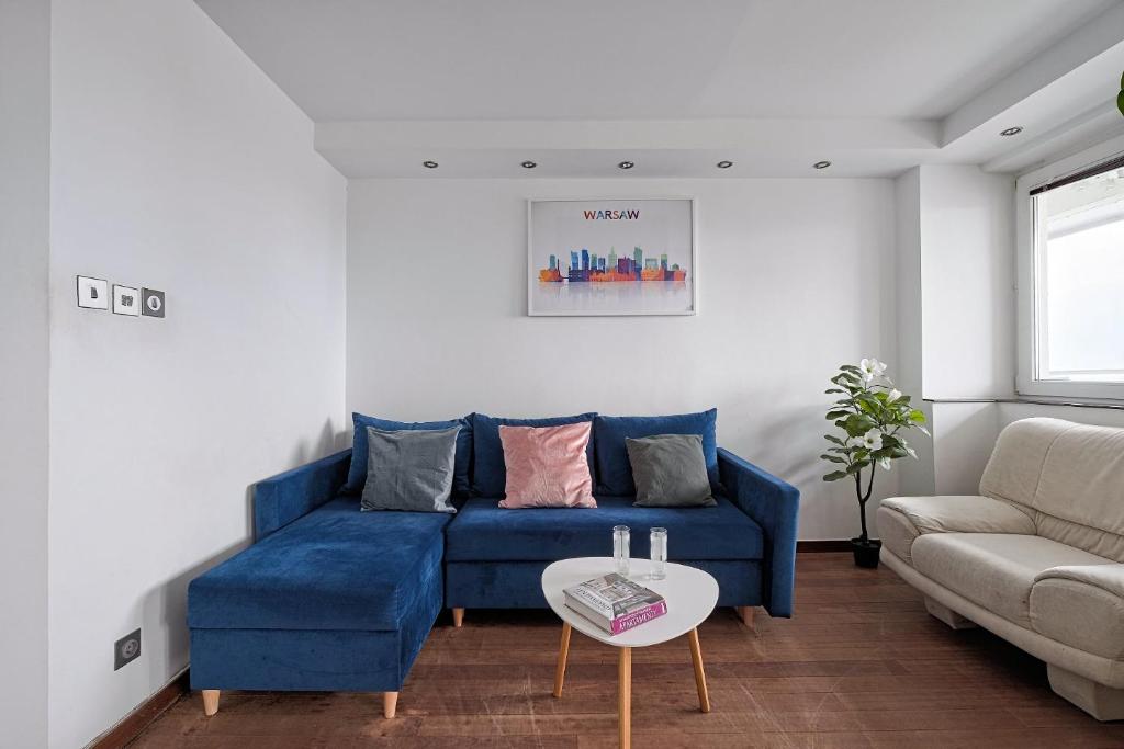 ワルシャワにあるCozy And Bright - City Center - Zgoda 13の青いソファとテーブルのあるリビングルーム