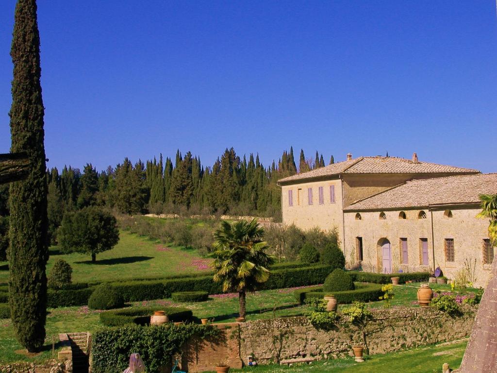 un gran edificio con un jardín delante de él en Castello di Grotti, en Corsano