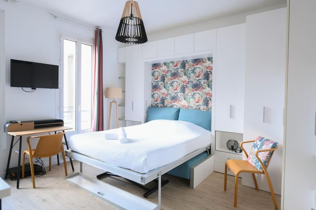 une chambre avec un lit, un bureau et une télévision dans l'établissement Shelter Oberkampf, à Paris
