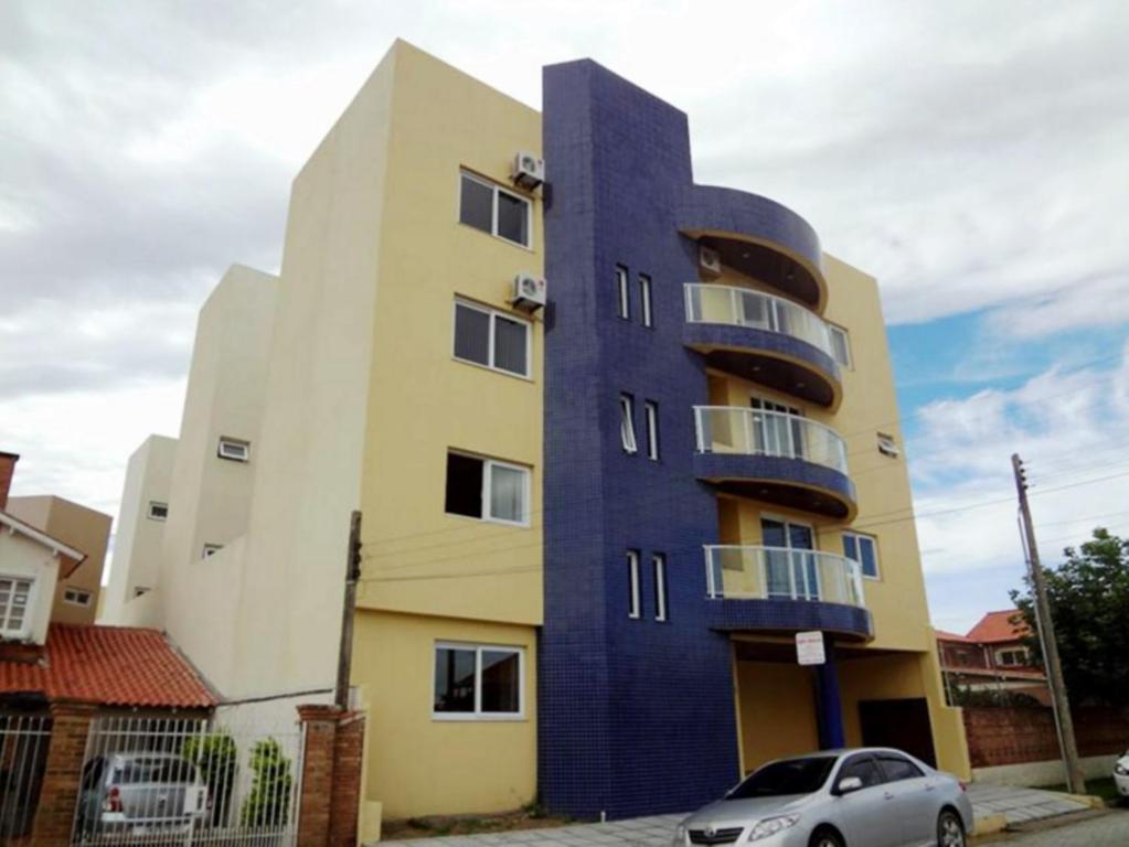 ein blaues Gebäude mit einem davor geparkt in der Unterkunft Hotel São Paulo in Rio Grande