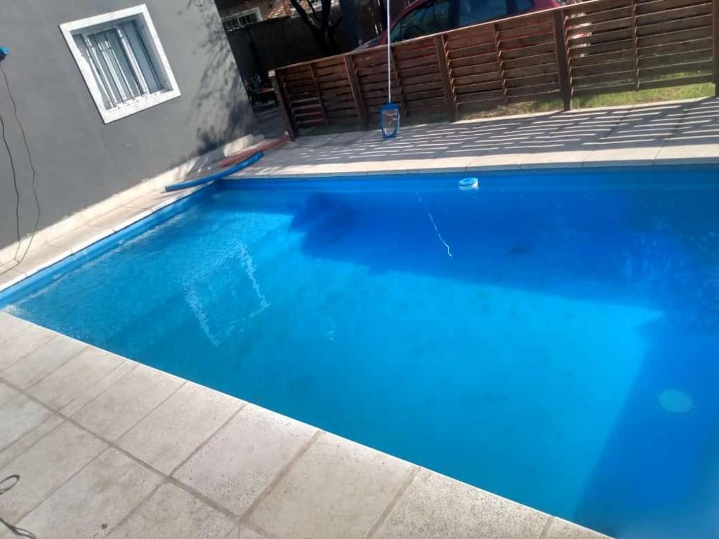 une grande piscine bleue à côté d'une maison dans l'établissement Cabañas La Mimi, à Villa Anizacate