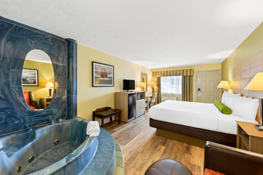 a hotel room with a bed and a bath tub at Best Western Dayton in Dayton