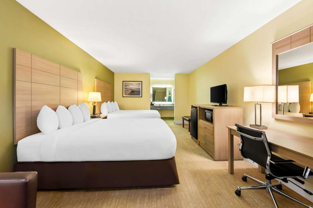 a hotel room with a large bed and a desk at Best Western Dayton in Dayton