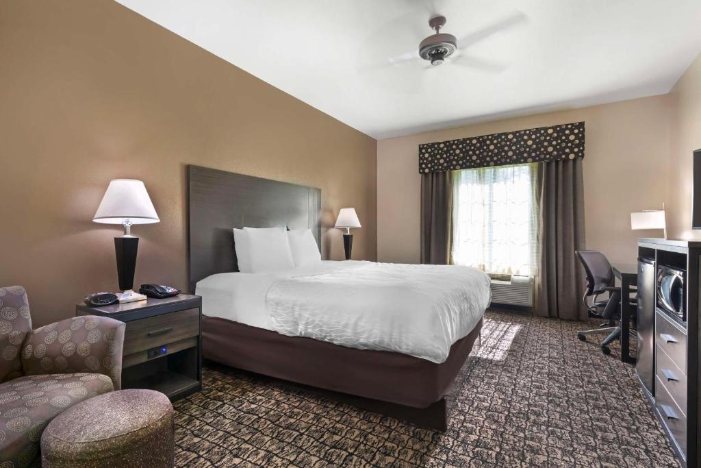 a large hotel room with a bed and a couch at Best Western Carthage Inn & Suites in Carthage