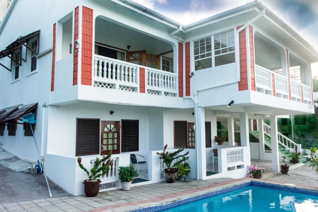 a house with a swimming pool in front of it at Cleopatra Villas - Sea View in Rodney Bay Village