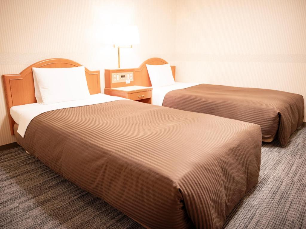 Postel nebo postele na pokoji v ubytování Numazu Grand Hotel