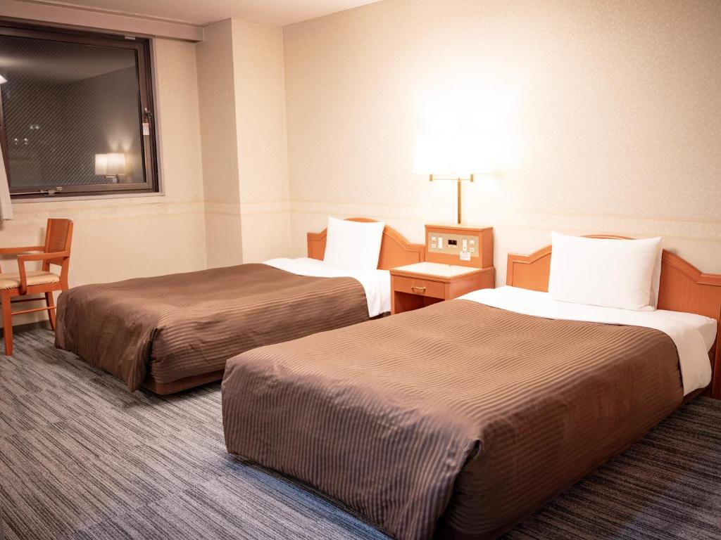 Postel nebo postele na pokoji v ubytování Numazu Grand Hotel
