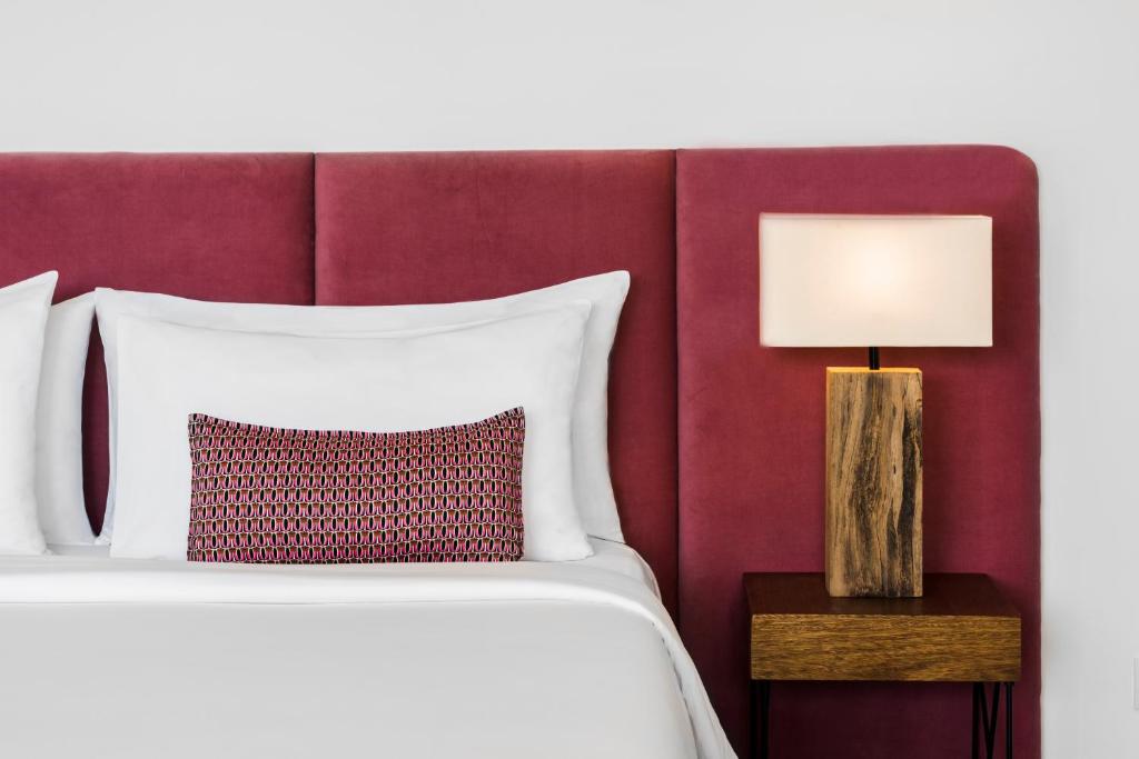 a bedroom with a bed with a red wall at Viroth's Hotel in Siem Reap
