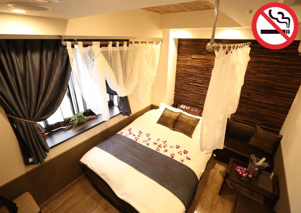 Postel nebo postele na pokoji v ubytování HOTEL PetitBali Higashi-Shinjuku
