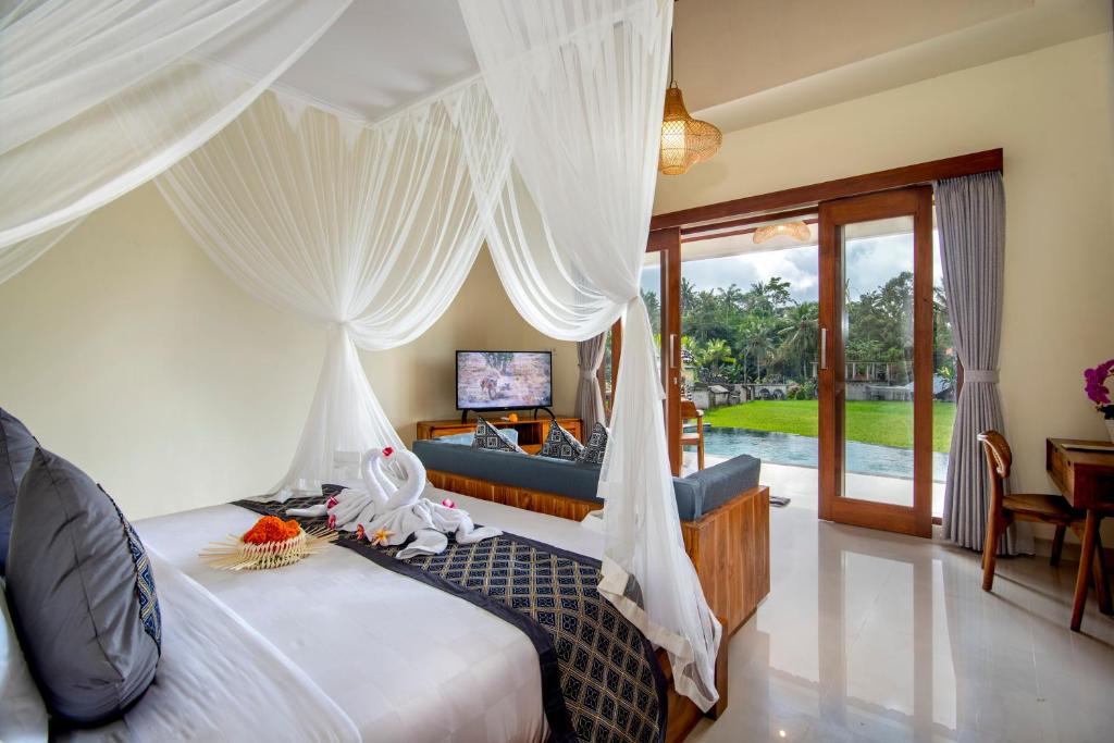 una camera con letto e un soggiorno di Jatining Ubud Villa & Spa ad Ubud