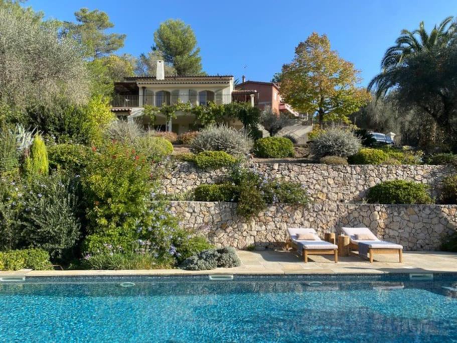 une maison avec un mur en pierre et une piscine dans l'établissement Batubela, à Mougins