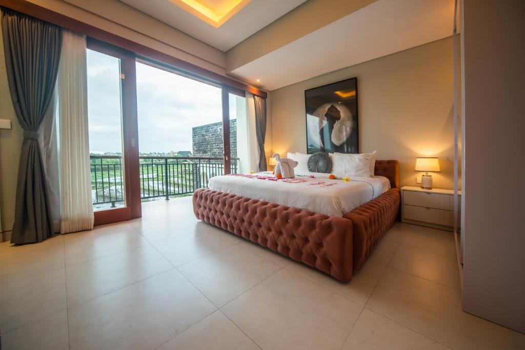 una camera da letto con un letto grande e un balcone di Alvana Villa Canggu a Canggu