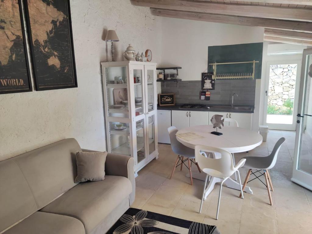 a living room with a couch and a table and chairs at La Fragna in Nardò