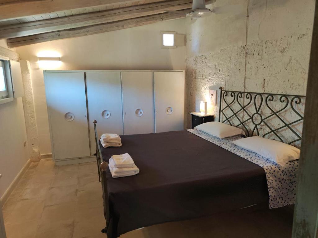 a bedroom with a black bed with white pillows at La Fragna in Nardò