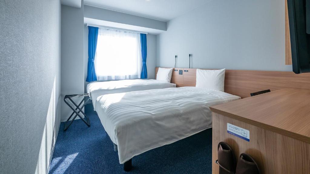 Postel nebo postele na pokoji v ubytování Toyoko Inn Koriyama