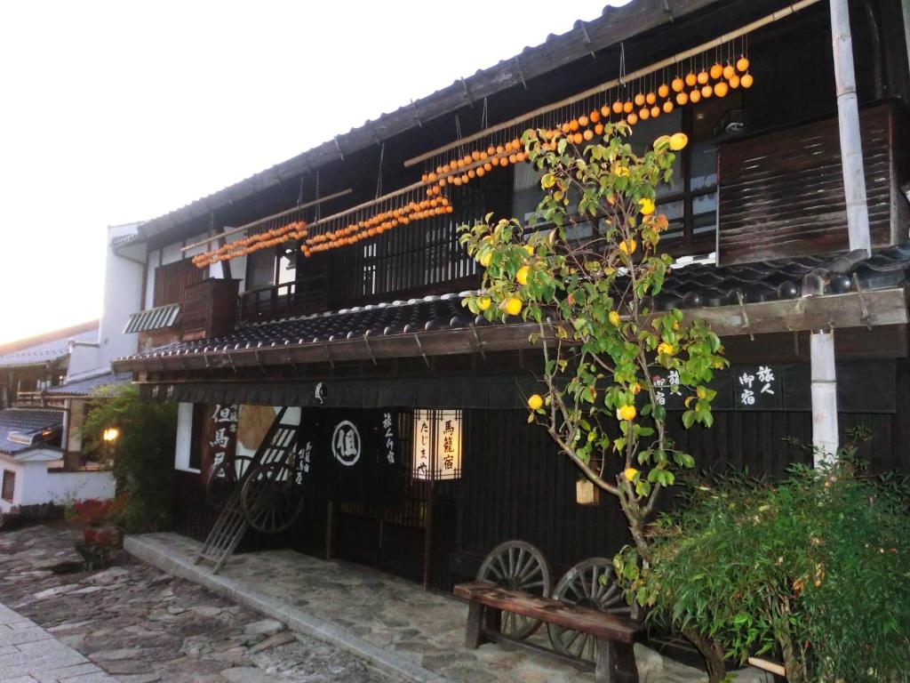 um edifício preto com um banco à frente em Tajimaya em Nakatsugawa